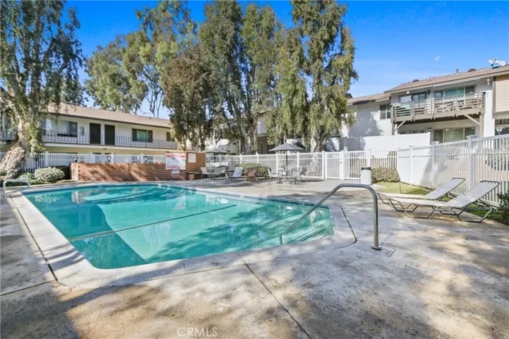 one of several pools in the complex, with BBQ area and lounge chairs and tables