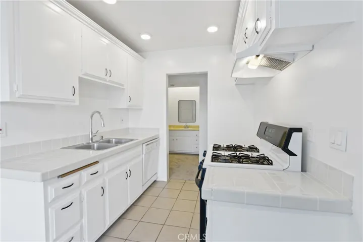 galley style kitchen, gas range with oven and a dishwasher with recessed lighting