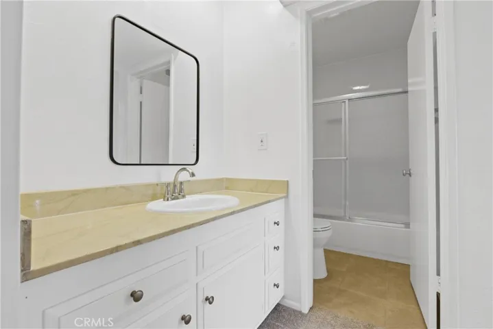 Sink with designer mirror and bathroom complete with a shower in a tub set-up
