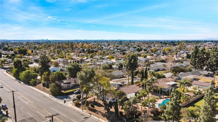 This photo shows the home from an aerial view. The lot is expansive, and the home is surrounded by trees.