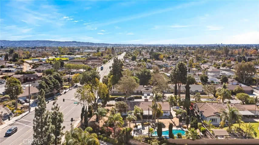 This photo shows the home from an aerial view. The lot is expansive, and the home is surrounded by trees.