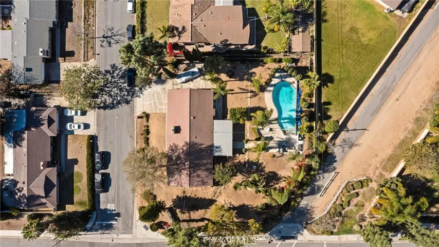 This photo shows the home from an aerial view. The lot is expansive, and the home is surrounded by trees.
