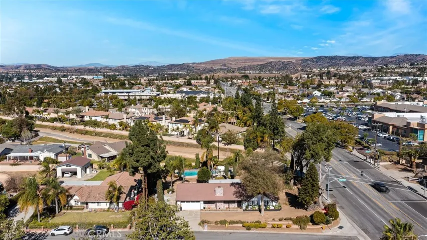 This photo shows the home from an aerial view. The lot is expansive, and the home is surrounded by trees.
