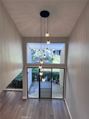 Livingroom with two-story ceiling and patio outside.