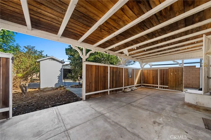 Back patio back house outhouse observed beyond fence