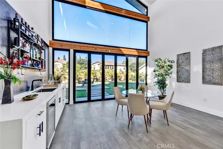 Family room has wet bar and wall of glass with high transom windows and an entire wall of bi-folding doors that open for a smooth transition from inside to outside living space