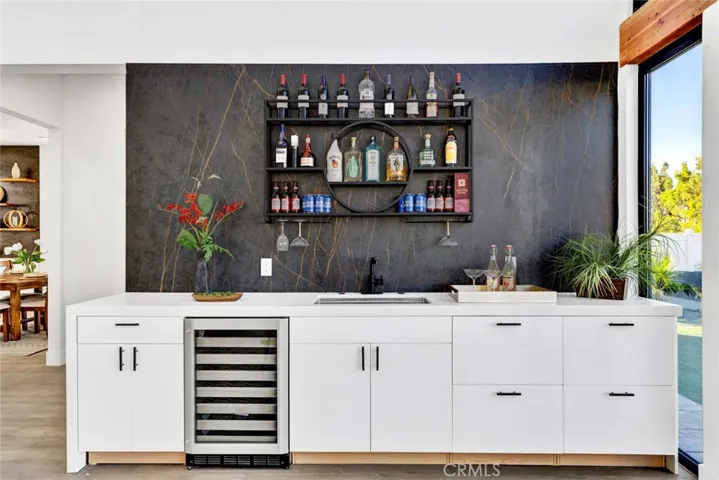 Wet bar in family room has Quartz counters and built-in wine fridge