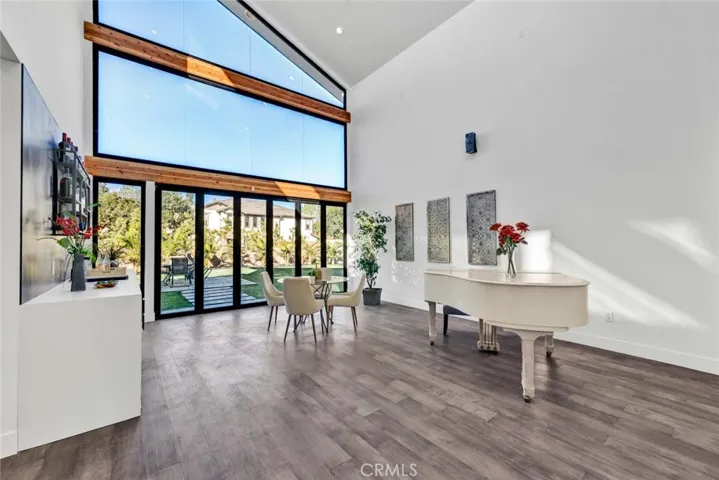 Family room has wet bar and wall of glass with high transom windows and an entire wall of bi-folding doors that open for a smooth transition from inside to outside living space
