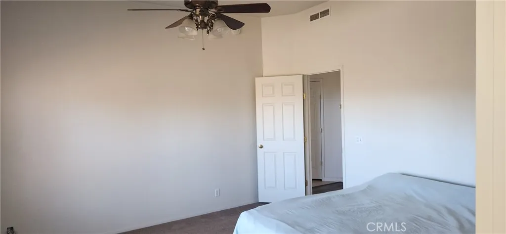 Main bedroom with lighted ceiling fan.