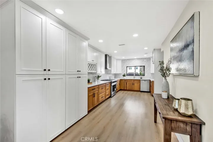 Large gourmet kitchen w/Quartz counters/backsplash, a walk-in pantry in additional to triple-wide pantries, and professional-grade stainless appliances including a Thor 6-burner gas range, high-capacity hood/vent, and Bosch dishwasher.