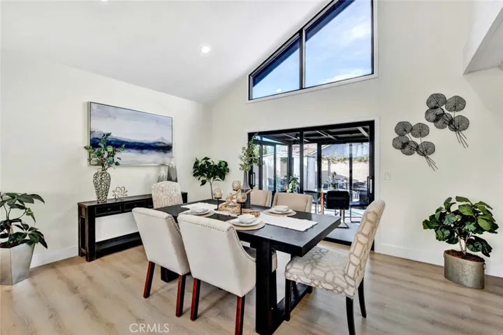 Formal dinning room with soaring ceiling, high transom windows for lots of natural light, LED recessed lighting, luxury-quality waterproof wood vinyl flooring