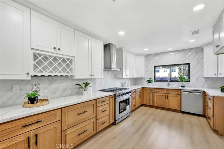 Chef's dream expanded kitchen w/Quartz counters and full backsplash, a walk-in pantry in additional to triple-wide pantries, and professional-grade stainless appliances including a Thor 6-burner gas range, high-capacity hood/vent, and Bosch dishwasher.
