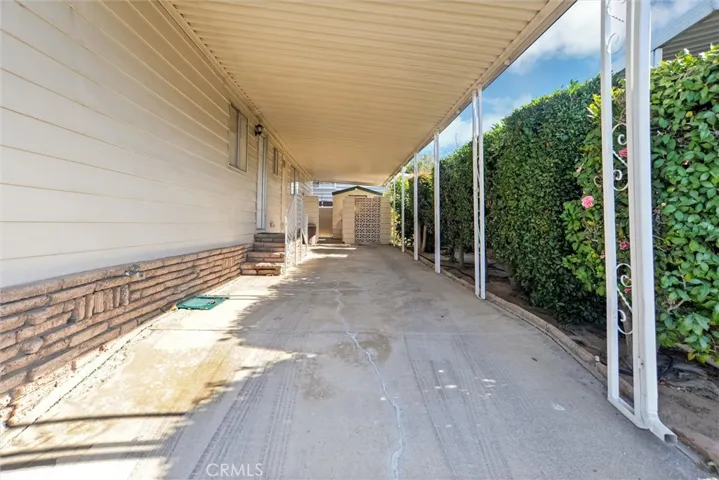Private Tandem car port area and extra-large storage shed behind the fence