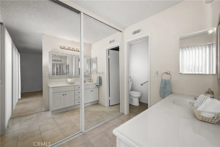 Master bathroom with mirrored wardrobe and private walk-in tiled shower and toilet