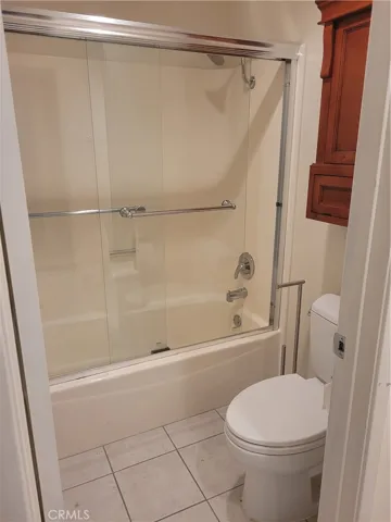 Upgraded Full bath at lower level with tiled floors, towel and supplies built in cabinet