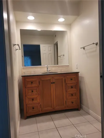 Updated Vanity area at lower level bathroom with tiled floors, cabinet with corrian tops, recessed lights