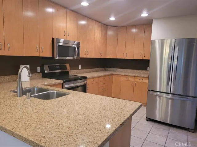 Gourmet upgraded Kitchen with lots of Cabinets, Storage, recessed lights, tiled floors, corrina counter tops and backsplash, stainless appliances, range/oven, microwave, refrigerator