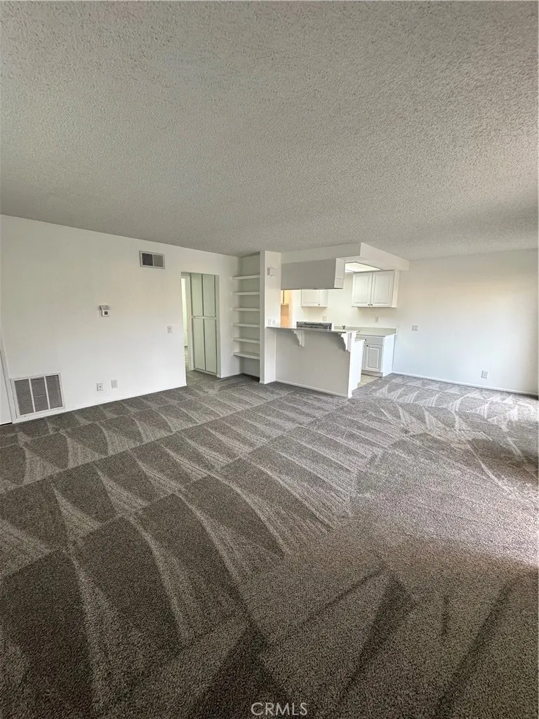 Full view of living room, kitchen dining room entry into the bedroom.