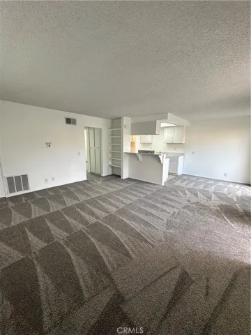 Full view of living room, kitchen dining room entry into the bedroom.