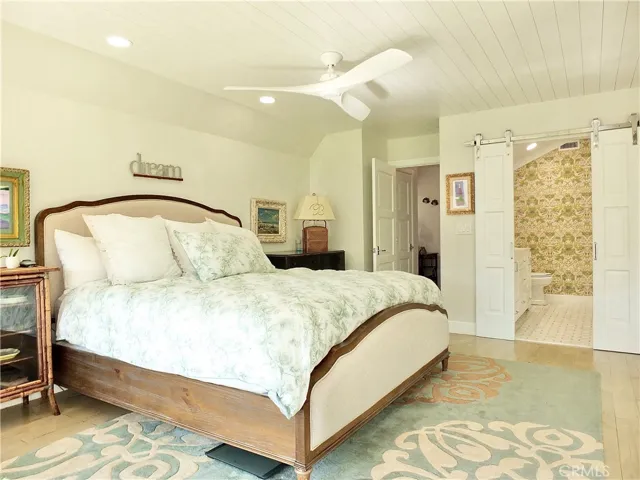 Custom wood panel ceiling and designer ceiling fan. Custom sliding  barn door to the bathroom.