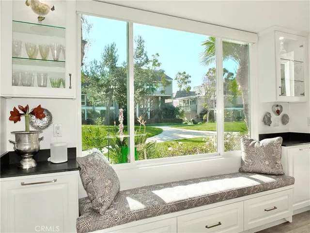 Custom window bench with drawers and pullout bar storage on each side with glass cabinet.
