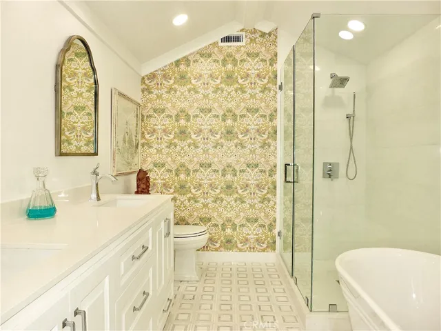 Soaking tub with large enclosed glass shower with hand held attachment.