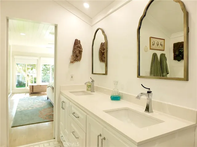 Double sink. Custom cabinet with quartz counter tops and designer mirrors.