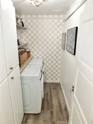 Side by side washer dryer and additional cabinets and open shelving.