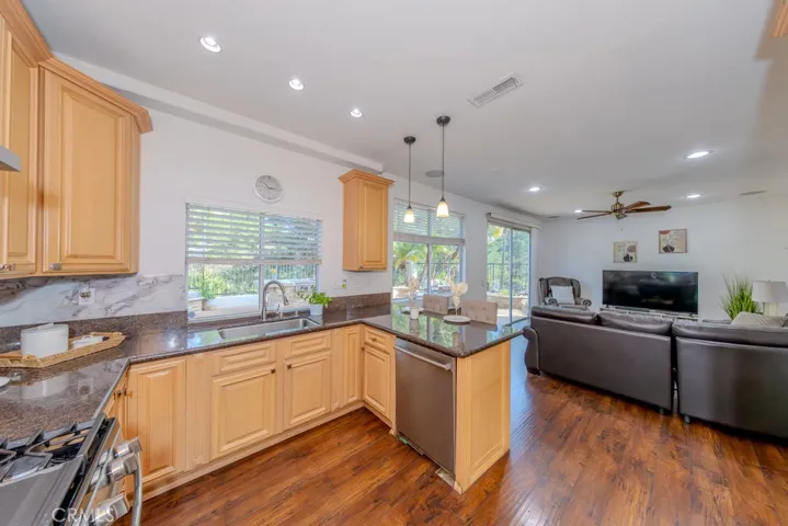 Kitchen features granite counters and stainless steel appliances with the adjoining family rooms.
