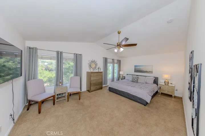 Primary bedroom with ceiling fan and views of the east and bacyard.