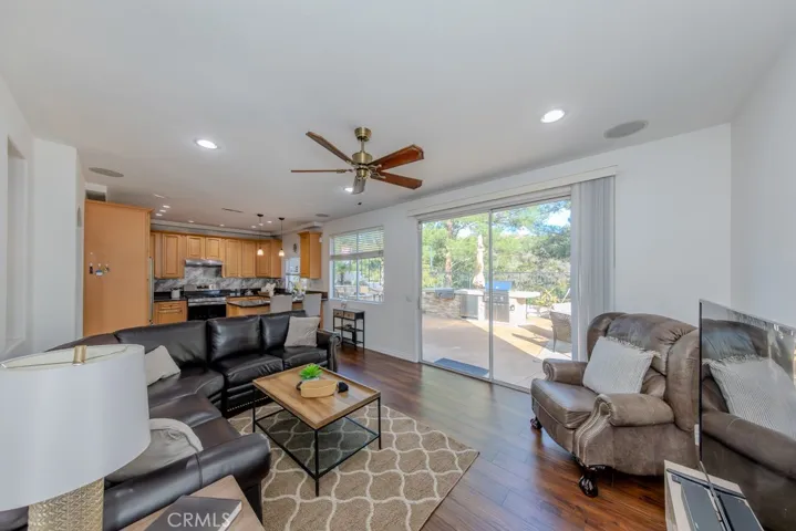 Family room with ceiling fan, recessed lighting, speakers, and slider access to the backyard.