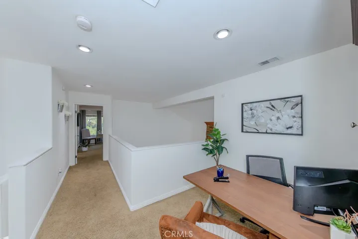 View of the loft/study area with the hallway to the primary bedroom.