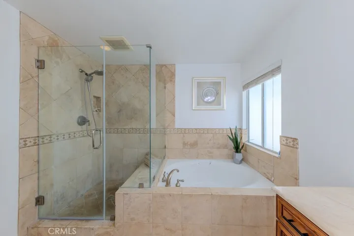Primary bathroom with walk in shower and sunken tub.