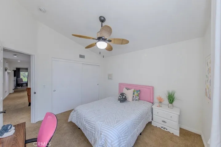 Northeast view of the second upstairs bedroom with a ceiling fan.