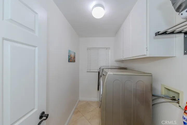 Downstairs laundry room with ample storage across from the bathroom and garage door access.