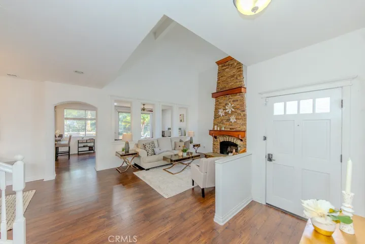 View of the entry and living room with a distinctive floor to ceiling fireplace.