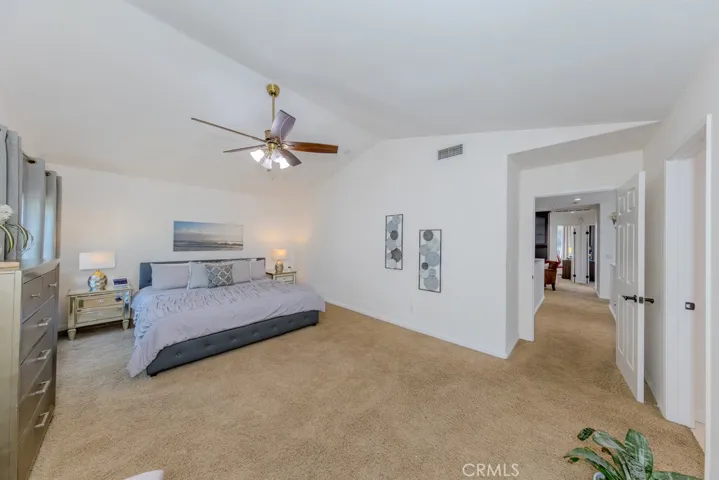 View of the spacious primary bedroom with ceiling fan.