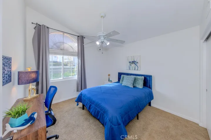 One of the two upstairs bedrooms with ceiling fan and west view of the street.