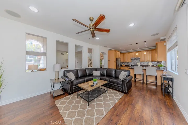 View of the family room with ceiling fan and flowing nicely into the kitchen with view access to the living room.