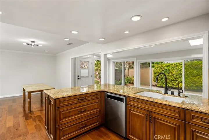 Nicely upgraded kitchen with granite countertops, travertine tile backsplash