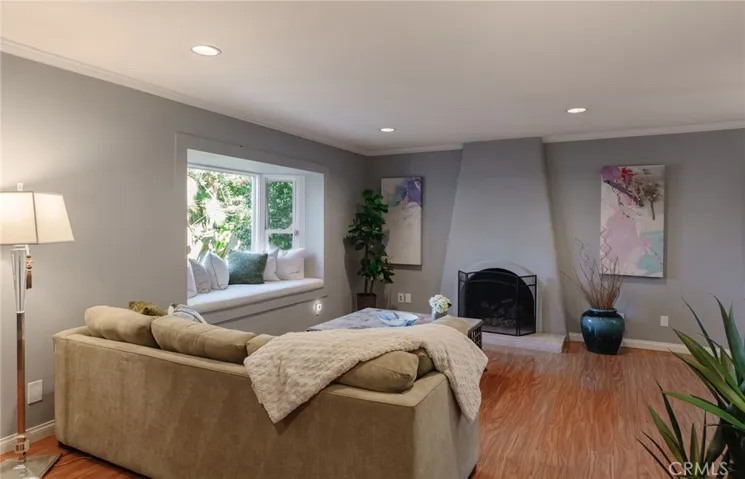 Living room with bay window, window seat, and fireplace