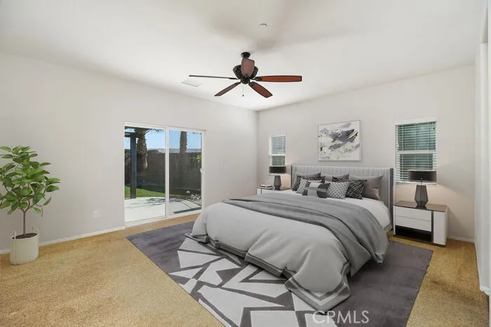The primary bedroom offers separation from the other bedrooms and access to the expansive patio