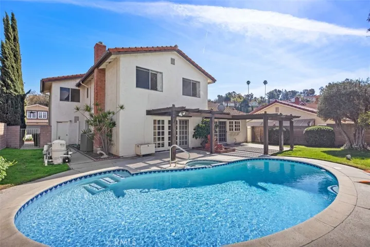 Back of the house is great for entraining with sweeping views, pool, jacuzzi, hard & soft scape, fruit tree, and more room to develop more.