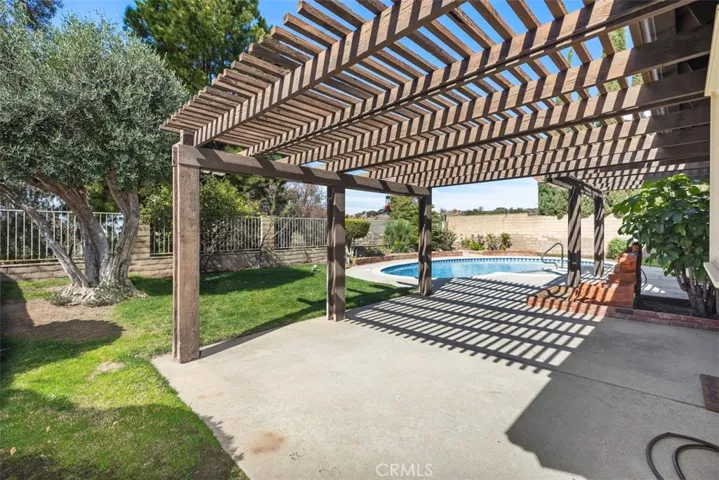 Back of the house is great for entraining with sweeping views, pool, jacuzzi, hard & soft scape, fruit tree, and more room to develop more.