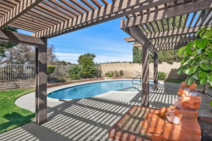 Back of the house is great for entraining with sweeping views, pool, jacuzzi, hard & soft scape, fruit tree, and more room to develop more.