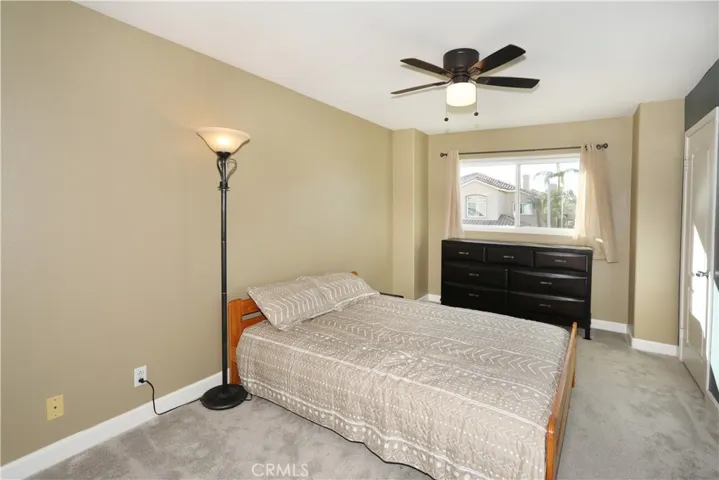 Bedroom #1, view out to the street, bathroom door connecting, fan