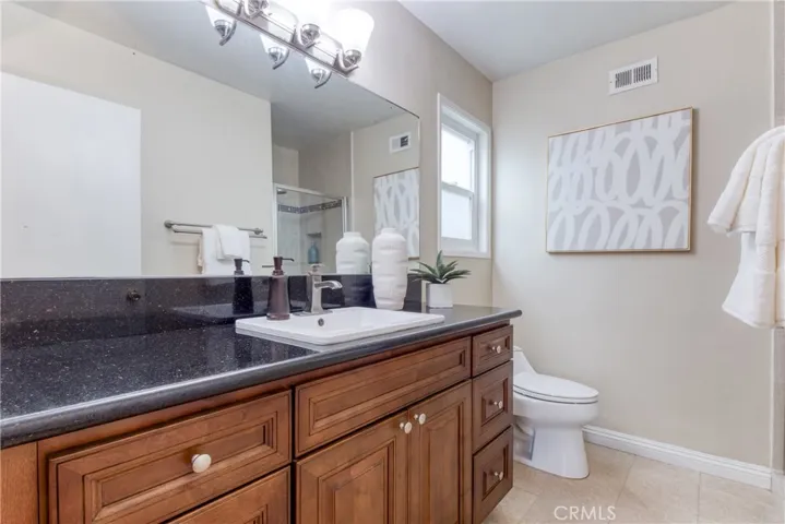 Remodeled Primary Bath with attractive shower, bathroom cabinetry and granite countertop~