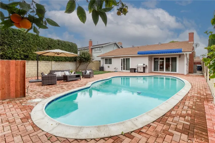 This backyard is truly an oasis with its sparkling pool & brick decking~