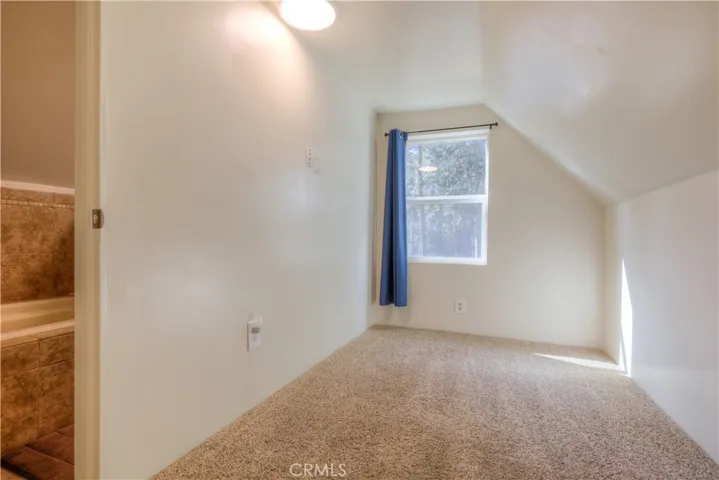 Bedroom with door entrance into the upstairs bathroom looking at the soaking tub.