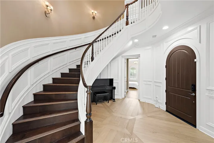 Curved staircase with custom wainscot paneling.